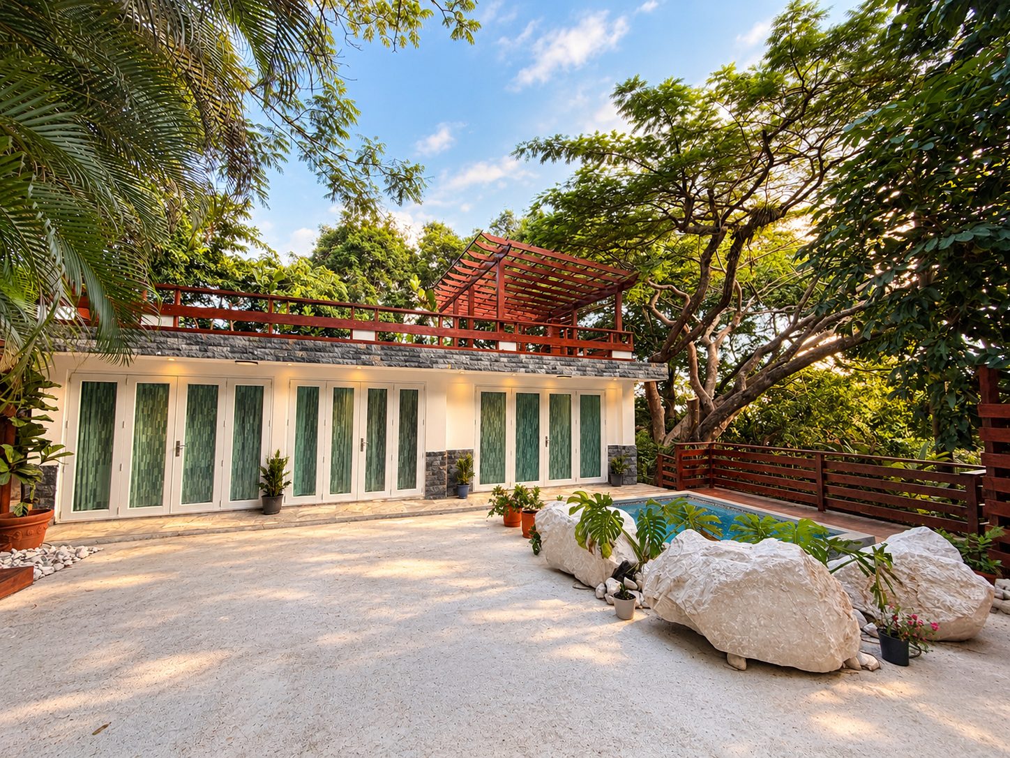 Edificio de CEN·SE con puertas de cristal verde, pérgola de madera en la terraza y jardín